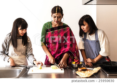 Young women learning Indian food 25950630