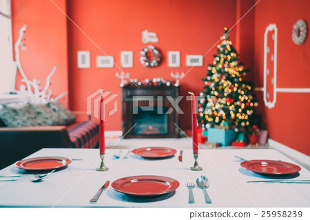 Beautifully laid new year table with red plates Beautifully laid new year table with red plates 25958239