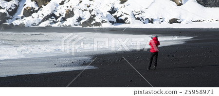 Photographer at black sand beach in Vik, Iceland Photographer at black sand beach in Vik, Iceland 25958971