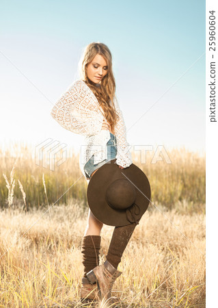 Beautiful young lady model posing in a field Beautiful young lady model posing in a field 25960604
