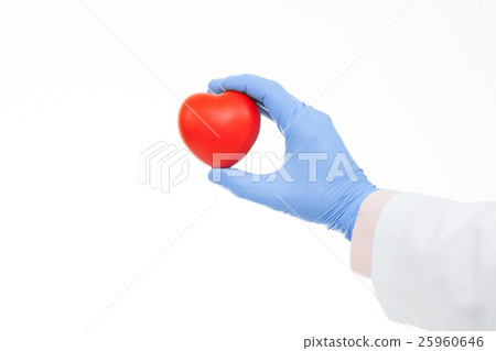 Doctor hand in a rubber glove holding toy heart 25960646