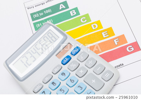 Calculator over colorful energy efficiency chart 25961010
