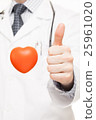 Doctor showing thumb up with toy heart near 25961020