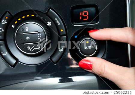 Stock Photo: Woman turns on air conditioning in a car