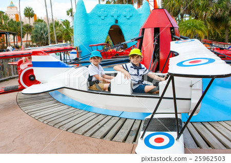 Two little funny kid boys riding on roundabout Two little funny kid boys riding on roundabout 25962503