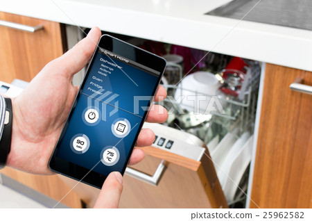 Man turns on the dishwasher by smartphone. 25962582