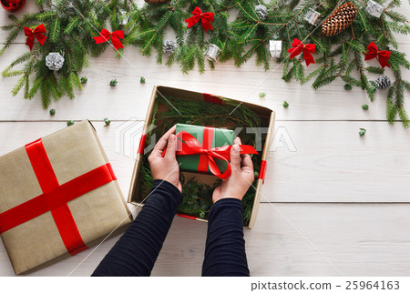 Wrapping christmas present gift on white wood Wrapping christmas present gift on white wood 25964163