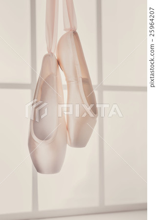 Pink ballet pointe shoes hanging on window Pink ballet pointe shoes hanging on window 25964207