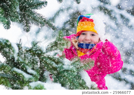 Little girl with icicle in snowy winter park 25966077