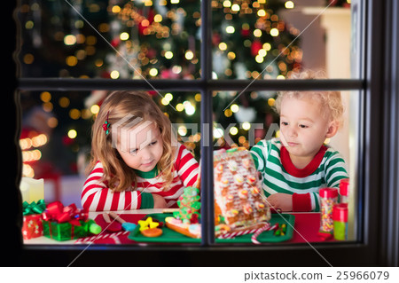 Kids making Christmas ginger bread house Kids making Christmas ginger bread house 25966079