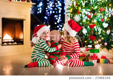 Kids in pajamas under Christmas tree Kids in pajamas under Christmas tree 25966168