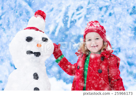 Little girl building a snow man 25966173