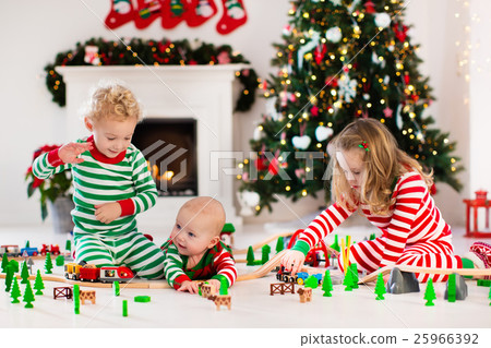 Kids play with toy railroad on Christmas morning Kids play with toy railroad on Christmas morning 25966392