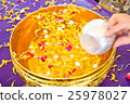 Water in bowl mixed with perfume and  flowers 25978027