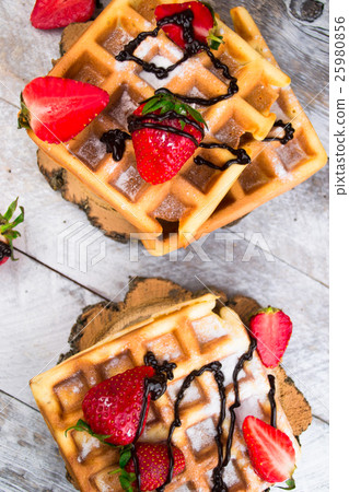 Belgium waffles with strawberries and chocolate.  25980856