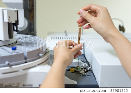 Scientist shooting sample in analytical instrument Scientist shooting sample in analytical instrument 25981223