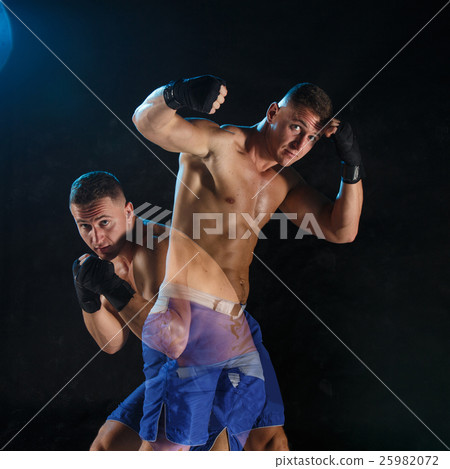 Male boxer boxing in a dark studio 25982072