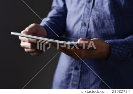 young man using his tablet computer young man using his tablet computer 25982724