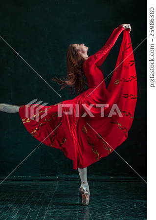 Ballerina posing in pointe shoes at black wooden 25986380