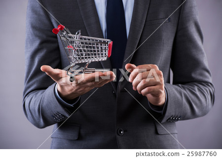 Buisinessman holding shopping cart in online Buisinessman holding shopping cart in online 25987760