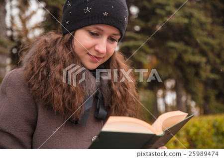 girl is reading a book in a park girl is reading a book in a park 25989474