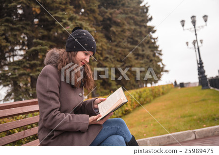 girl is reading a book in a park girl is reading a book in a park 25989475