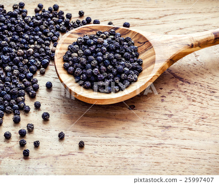 Closeup black pepper in wooden spoon . 25997407