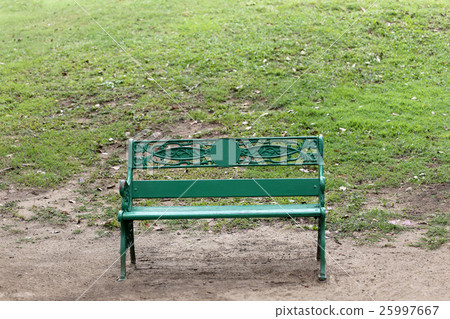 Green chair or bench on ground in public park. Green chair or bench on ground in public park. 25997667