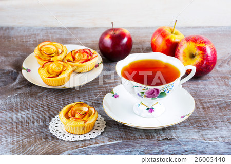 Cup of tea and small apple roses shaped pies Cup of tea and small apple roses shaped pies 26005440