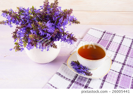 Cup of tea on checkered napkin and purple flowers 26005441