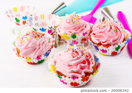 Homemade pink birthday cupcakes and cookware Homemade pink birthday cupcakes and cookware 26006342