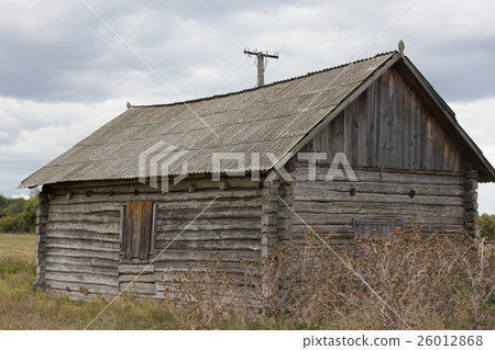 Old wooden house stands among villages and 26012868