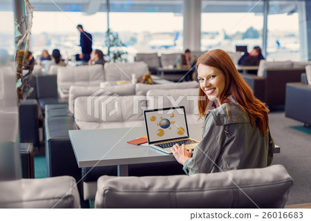 Beautiful girl using laptop in airport Beautiful girl using laptop in airport 26016683