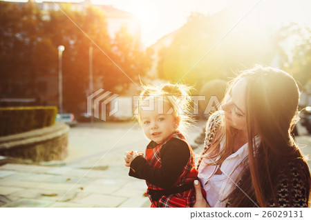 Mother and little daughter playing in a park Mother and little daughter playing in a park 26029131