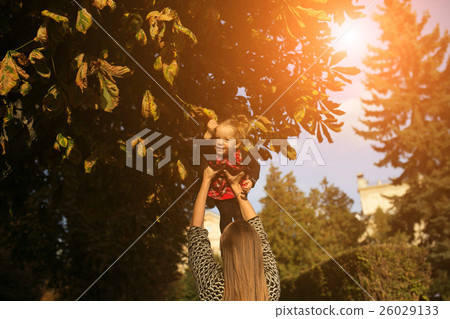 Mother and little daughter playing in a park Mother and little daughter playing in a park 26029133