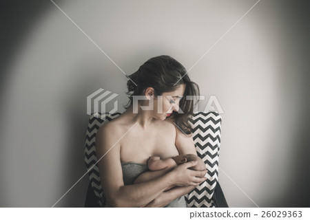 Young mother holding her newborn child. Mom nursing baby. Young mother holding her newborn child. Mom nursing baby. 26029363