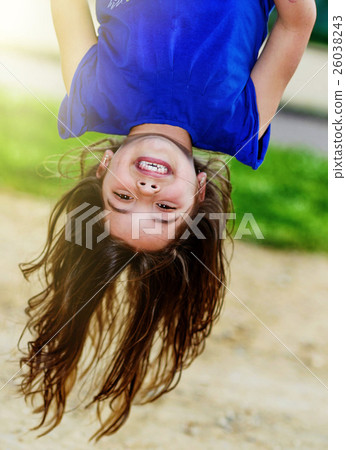 kid hanging upside down on the monkey bars 26038243