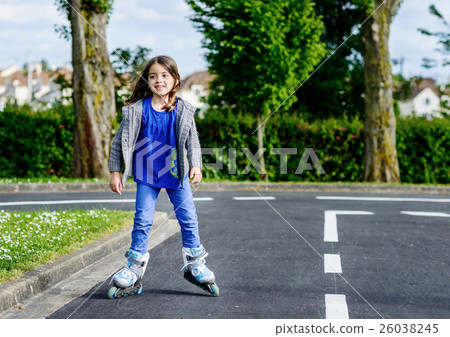 little girl doing rollerblade in the street 26038245