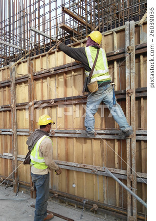 Construction workers fabricating timber form work  26039036