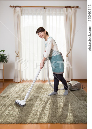 A young lady wearing a vacuum cleaner 26040341
