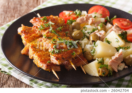 Spanish skewers Pinchos Morunos and potato salad 26042704