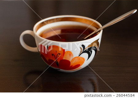 Closeup cup of tea with a floral pattern and spoon 26044584