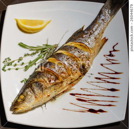 Oven-baked Sea bass with lemon and herbs Oven-baked Sea bass with lemon and herbs 26044679