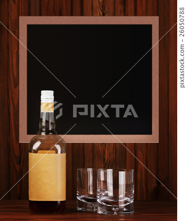 Glasses with ice for whiskey and bottle on wooden background. 26050788