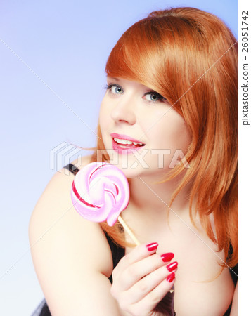 Redhair girl holding sweet food lollipop candy on blue. 26051742