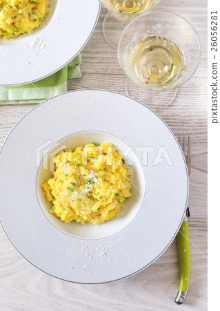 Risotto with saffron and glass of white wine 26056281