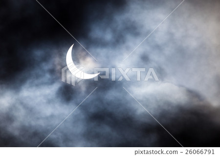Partial solar eclipse through clouds 26066791