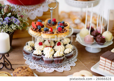 Table with various cookies, tarts, cakes, cupcakes 26066828