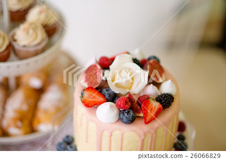 Cake with various berries and meringues on a stand 26066829