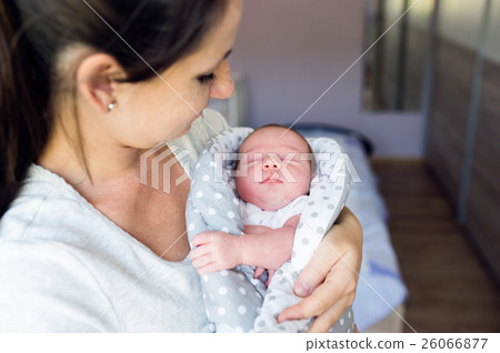 Beautiful mother holding newborn baby son in her 26066877